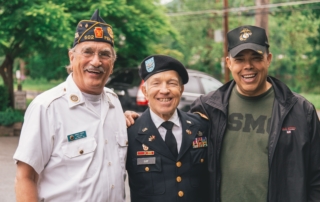 three elderly veterans standing together