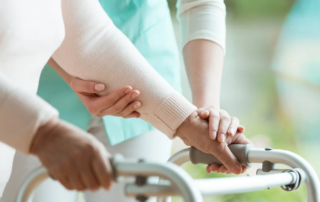 Closeup of elderly lady's hands holding a walker and supporting nurse helping her